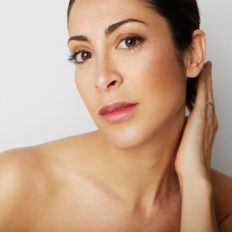 Portrait of handsome beauty woman with big brown eyes and dark eyebrows looking away over empty white background.Model with light nude make-up.Healthcare skin concept