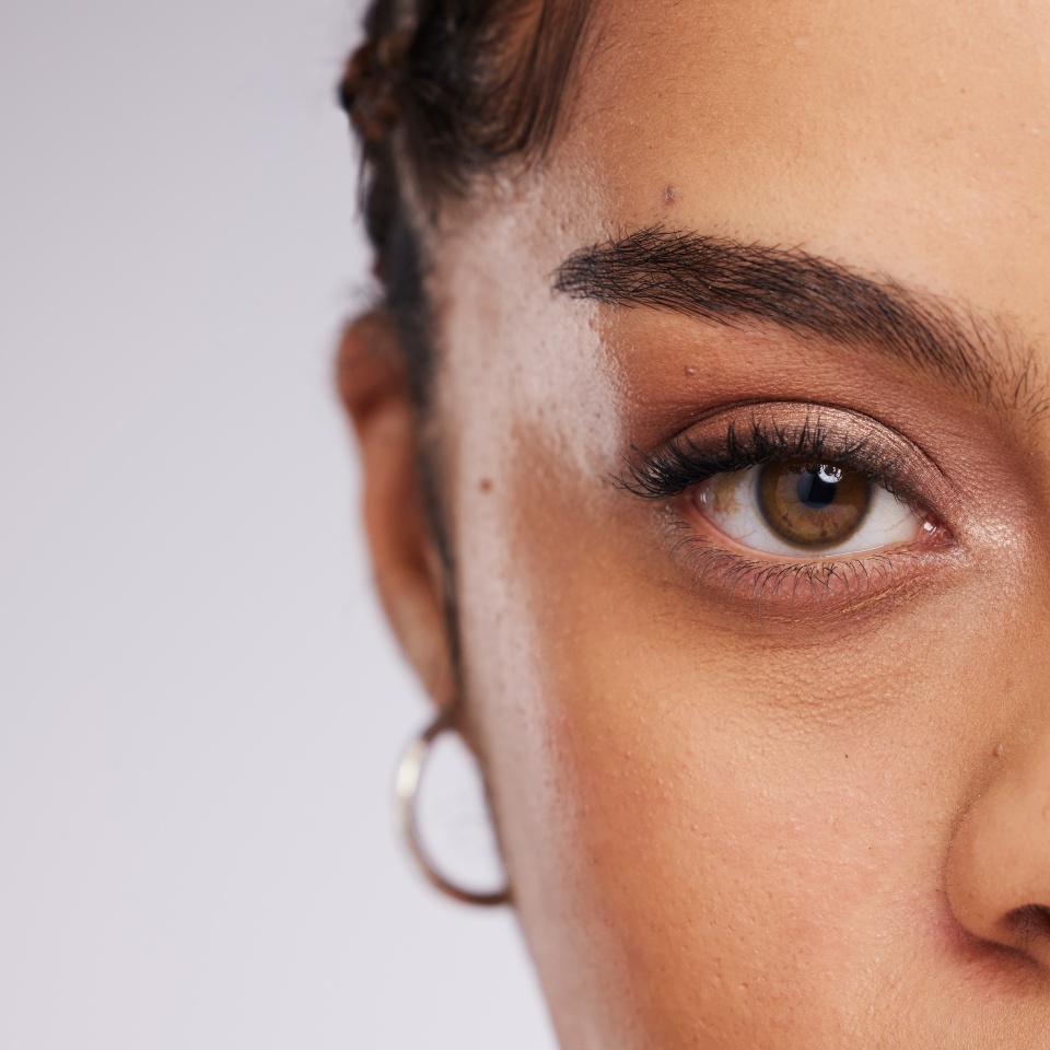 Eye, vision and beauty with contact lens and black woman, care for eyes and cosmetics with closeup on studio background. Microblading, eyebrow and lashes, face and skin in portrait with mockup space