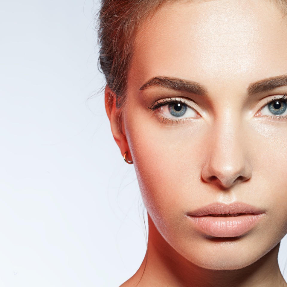 Close-up portrait of young woman with perfect skin clean with a red reflex in the face