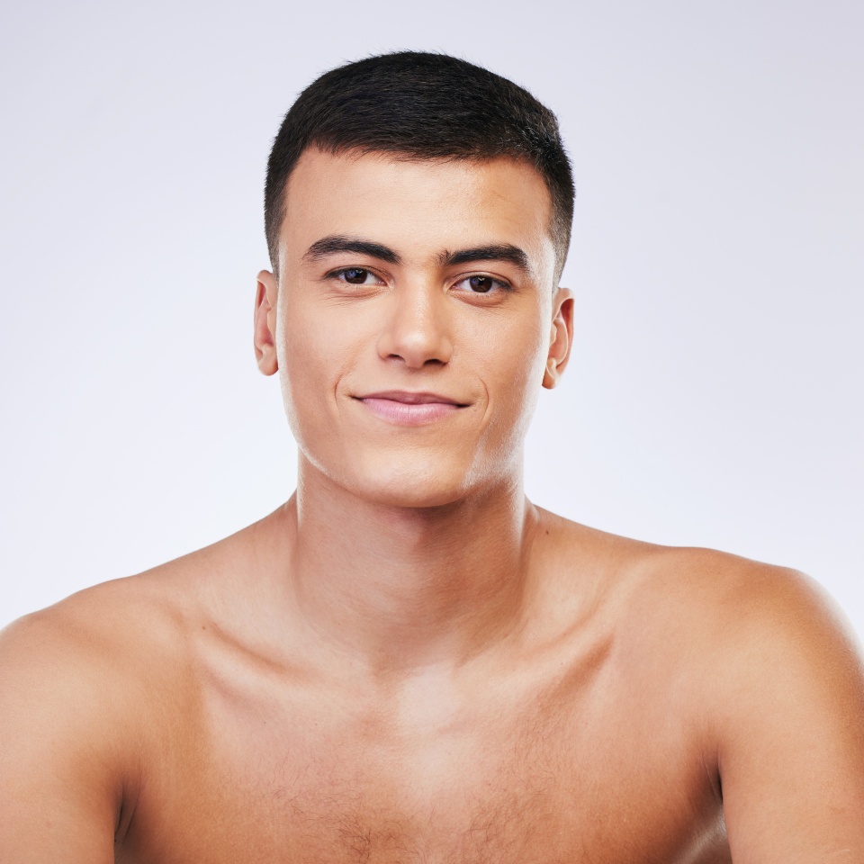 Man, beauty and face with skin, smile and grooming for hygiene and clean isolated on white background. Portrait, model and dermatology, skincare and treatment with cosmetics and wellness in a studio