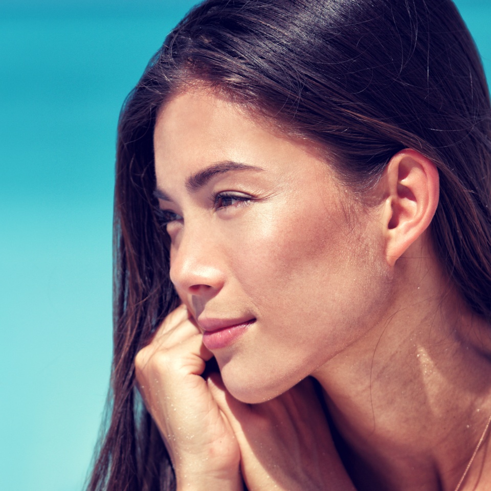 Young Asian beauty woman face closeup portrait. Mixed race Chinese Caucasian girl profile with healthy glowing skin and natural makeup on cheeks, eyelids, eyebrows, lips. Skincare concept.